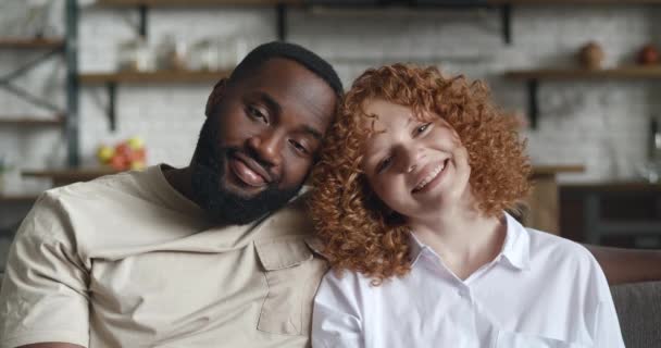 Retrato de adorable pareja interracial amorosa, abrazándose, lindo sonriendo con una sonrisa dentada mirando a la cámara posando en el fondo de la cocina de su apartamento en casa — Vídeos de Stock