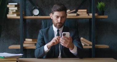 Smartphone 'daki şok olmuş adam ev oturma odasındaki kanepede otururken ağzını korkuyla kapatıyor. Nahoş bir şekilde şaşırmış ve korkmuştu. Erkek, gördüğü şey karşısında şoke olur..