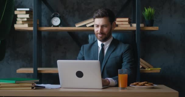 微笑的商人在现代办公室的笔记本电脑上工作。在现代办公室工作场所的计算机上有胡子的男性企业家专业打字. — 图库视频影像
