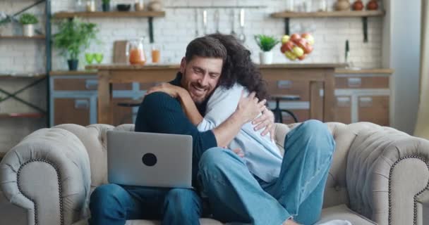 Fiatal család boldog pár használja laptop olvasni nagy hír az öröm ünneplő hihetetlen lehetőséget. Néhány szerencsejátékos ünnepli lottó monetáris győzelem, aukció és fogadási siker koncepció, kanapén otthon — Stock videók