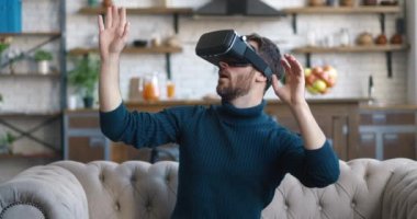 Genç hippi, 360 videosunu izlemek için sanal gerçeklik gözlüğü kullanıyor ya da evdeki kanepede otururken arttırılmış gerçeklik oyunları oynuyor..