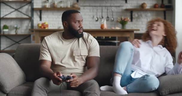 Afroamericano adicto a los juegos de ordenador, presionando el joystick, pierde mientras juega activamente juegos de ordenador. Novia se burla de su novio perder — Vídeos de Stock