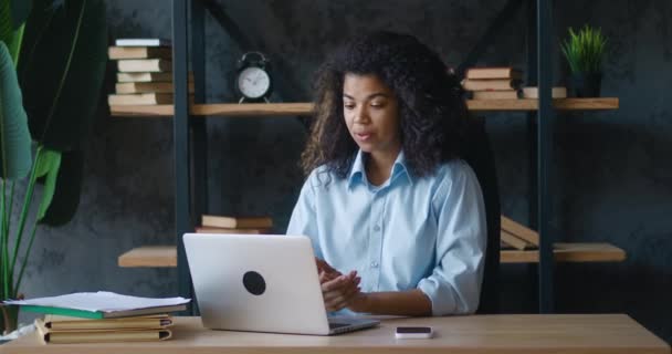 Jovem afro-americana mulher de negócios vídeo conversando com laptop no escritório. Gerente do sexo feminino falando e olhando para a tela do laptop enquanto sentado na mesa. Conceito webinar Webcam — Vídeo de Stock