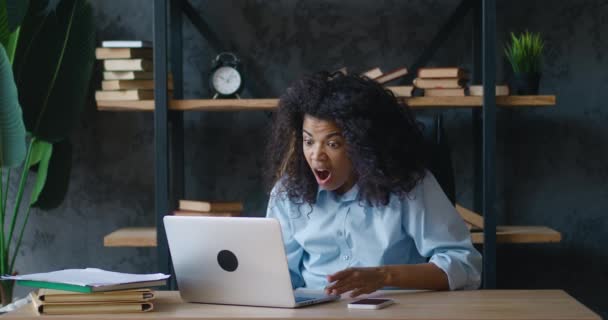 Σοκαρισμένη Αφρικανή επιχειρηματίας αναστατωμένη με κακή συμφωνία, κοιτάζοντας οθόνη laptop, αντίδραση σε κρίση. Δυσάρεστα έκπληκτος φοιτητής γυναίκα από το κακό e-mail δει στον υπολογιστή, ενώ εργάζονται στο γραφείο. — Αρχείο Βίντεο