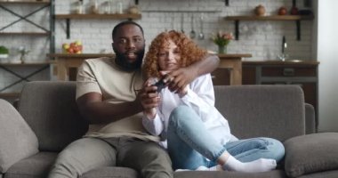 Afrikalı Amerikalı bir adam ve beyaz bir kadın, bilgisayar oyunu bağımlısı, oyun oynarken joystick 'e tıklayan, izin günlerinde oyun oynarken heyecanlanan. Hafta sonu eğlencesi