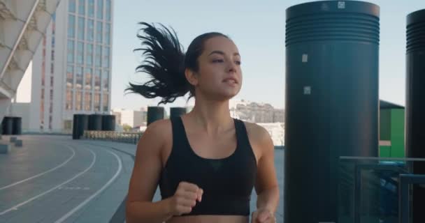 Z przodu widok szczęśliwej atletycznej kobiety biegającej na świeżym powietrzu w zwolnionym tempie. Fitness dziewczyna robi trening cardio, działa rano na ulicach miasta — Wideo stockowe