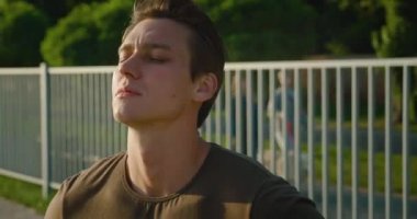 Formdan önce ısınan yakışıklı ve güçlü bir adamın portresi. Stadyumda poz veren sağlıklı atletizm modelleri..