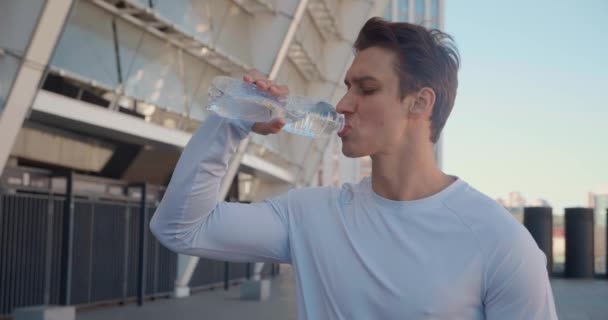 Knappe jongeman die schoon water drinkt na cross fit training. — Stockvideo