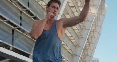 Egzersiz yaparken yakışıklı bir erkek boksör boks antrenmanı yumruğu. Stadyumda üstsüz bir sporcunun portresi.