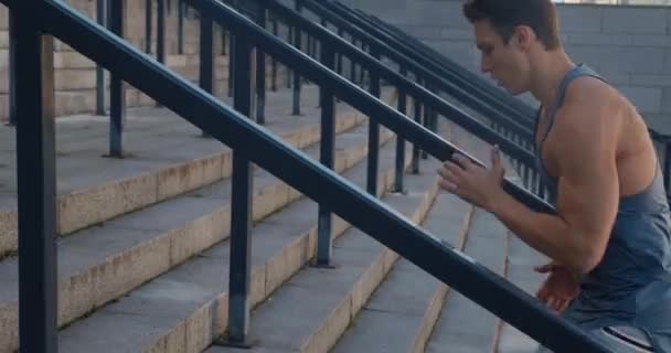 Jeune homme athlète en cours d'exécution dans les escaliers entraînement cardio intense exercice coureur homme jogging sur les marches en milieu urbain — Video