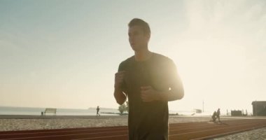 Spor adamı dışarıda koşuyor. Stadyumda koşan adamın portresi. Gün batımında dışarıda spor yapıyorum. Atletik eğitim koşusu egzersizi