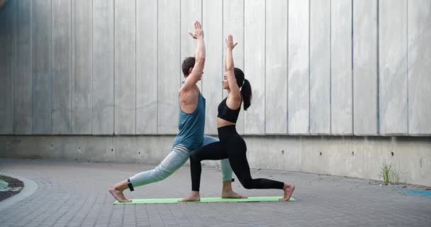 Młoda atrakcyjna para ćwiczy jogę rozciągając trening na świeżym powietrzu zdrowy styl życia pielęgnacja ciała — Wideo stockowe