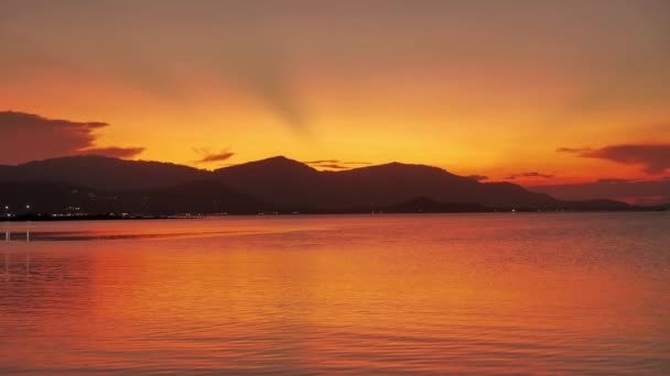 Bellissimo tramonto sul mare con montagne sullo sfondo. Alba tropicale arancione sull'oceano sullo sfondo delle montagne. Sogni di Paradiso — Video Stock