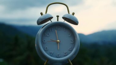 Klasik çalar saat sabahın erken saatlerinde dağların arka planına karşı. Zaman kavramı