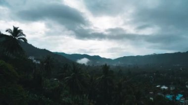 Bulutlu tropik yağmur ormanları zaman atlamasında hareket eder. Tayland, Ko Samui 'deki adanın tropik bölgelerindeki dağlara yağmur bulutları yağıyor. Zaman aşımı 4K. Yeşil manzara.