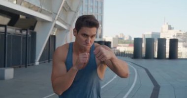 Egzersiz yaparken yakışıklı bir erkek boksör boks antrenmanı yumruğu. Stadyumda üstsüz bir sporcunun portresi.