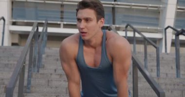 Atletik sporcu, stadyumda koştuktan sonra dinleniyor..