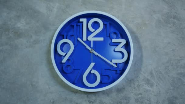 Un orologio da ufficio blu pende su un muro di cemento grigio. Time lapse, timelapse — Video Stock