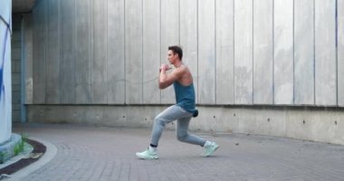 Genç atletik adam çömelme egzersizleri yapıyor, tek başına spor antrenmanı yapıyor. Açık havada egzersiz.. 