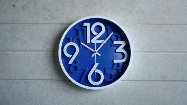 Une horloge de bureau bleue est accrochée à un mur de béton gris. Temps écoulé, temps écoulé — Video