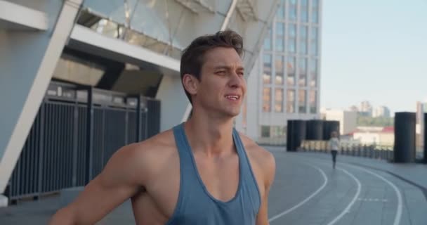 Atletische man opwarming en strekken van zijn armen om klaar te zijn voor training buiten op het stadion. — Stockvideo