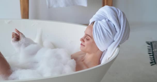 Close-up beauty portret van mooie vrouw chillen thuis, rusten in bad met schuim, wassen van haar lichaam, verzorgen van haar huid, spelen met zeepbellen, kijken tevreden. SPA, zuiverheidsconcept — Stockvideo