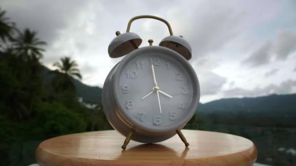 Time lapse of vintage alarm clock on tropical nature background. Time concept — Stock Video