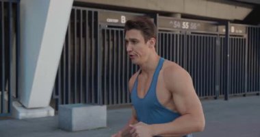 Dışarıda koşan yakışıklı bir sporcu. Stadyumda koşan adamın portresi. Gün batımında dışarıda spor yapıyorum. Atletik eğitim koşusu egzersizi