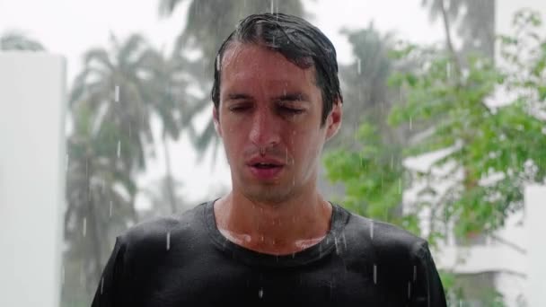 Retrato de un hombre triste llorando parado bajo la lluvia y empapado. Disparo en cámara lenta — Vídeo de stock