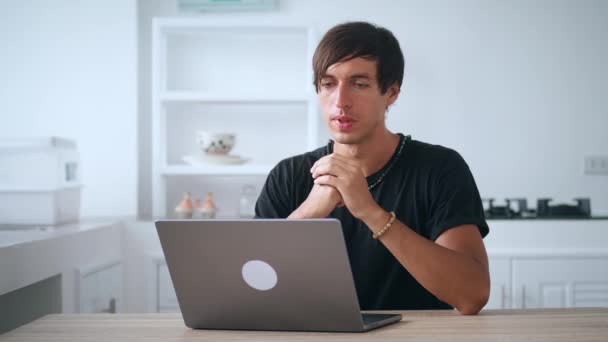 Joyeux jeune homme d'affaires appeler chat vidéo sur ordinateur portable sur le lieu de travail distant, assis à la table de la cuisine à la maison — Video