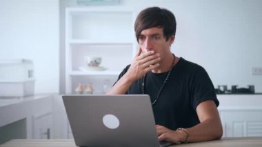 Korkak iş adamı, ofisteki bilgisayardan kötü sonuçlar alıyor. Genç erkek, dizüstü bilgisayardan kötü haberler izliyor ve evde mutfak masasında otururken ağzını dehşet içinde kapatıyor.