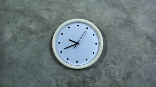 Reloj de oficina blanco cuelga de una pared de hormigón gris. — Vídeos de Stock