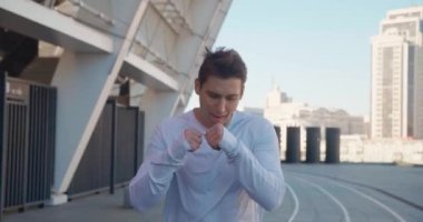 Dışarıda koşan yakışıklı sporcu boksörü. Stadyumda profesyonel bir sporcunun portresi, antrenmandan önce ısınıyor. Açık hava sporları eğitimi