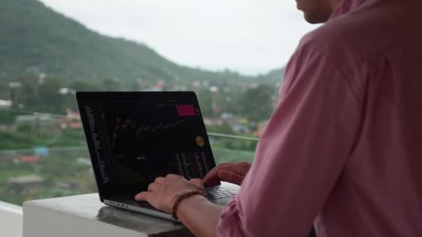 Pemandangan belakang pengusaha pemodal bekerja di pasar kripto keuangan pada komputer. Investor trader laki-laki bekerja dengan grafik keuangan — Stok Video