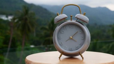 Yeşil doğa arka planında klasik çalar saat. Zaman kavramı