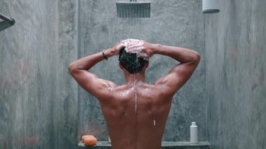 Back view Young Man Washing and Taking a Shower with Shower Bath and Washing Hair with Shampoo in Bathroom with Slow Motion.