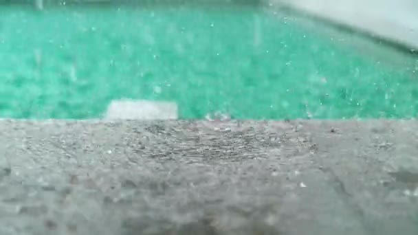 Big Rain Water Droplets Splash On the wet floor, near the Pool Outdoors in Slow motion. Rainy weather — стоковое видео