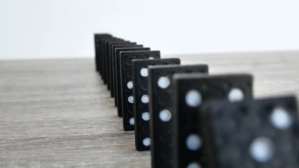 Zwarte dominostenen vallen in een rij - slow motion — Stockvideo