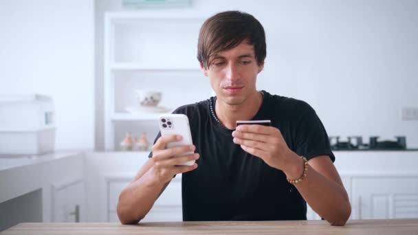 Giovane uomo online banking utilizzando smartphone shopping online con carta di credito a casa — Video Stock