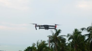 Quadcopter İHA 'sı gökyüzü arka planında geziniyor ve uçuyor