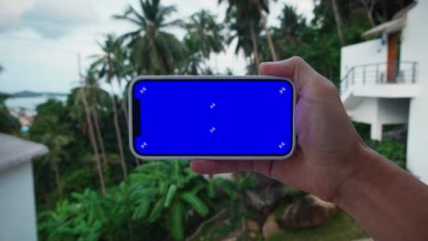 在室外 手部有一个水平智能手机的特写镜头 男性手持蓝屏彩色键手机 移动广告的视频 应用程序的宣传 高质量的4K镜头 — 图库视频影像