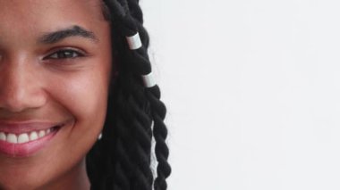 Close-up portrait of part of multiethnic womans face looking at camera and smiling beautiful healthy white toothy smile
