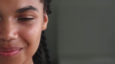 Partial view of the face of a smiling multi-ethnic woman with glowing skin. Beautiful people, femininity. Copy ad space