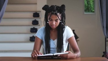 Serene cute woman leafing through the pages of a book enjoying reading literature in home interior. Erudition, education
