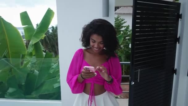 Attractive Woman Using Smartphone Checks Content While Entering Balcony Overlooking — Vídeos de Stock