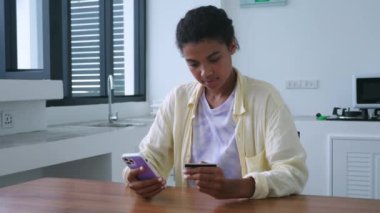 Beautiful woman using smartphone, transfers data from a credit card, makes online payments, shopping in internet stores