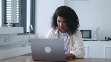 Multitasking young woman, entrepreneur, journalist, copywriter using laptop for online remote work, in the home interio