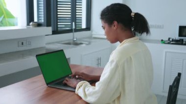 Hardworking woman freenalcer worker, copywriter working remotely on laptop with green chromakey screen, from home office