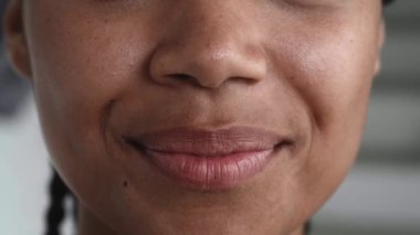 Close-up of glossy lips of natural beauty woman with fresh and glowing skin, cutely smiling at camera. Beautiful smile.