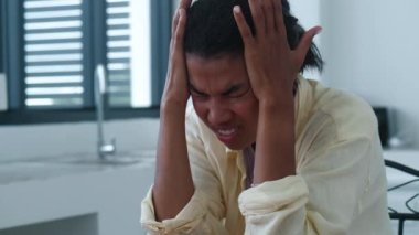 Young woman suffers from headache due to cranial pressure due to computer overwork, massages temples to relieve suffering